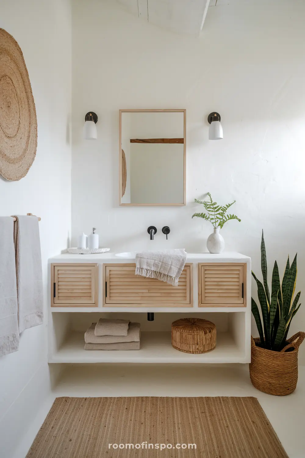 A Scandinavian-bohemian bathroom with a light wood floating vanity, white walls, and simple, airy decor for a calm and minimalist atmosphere.
