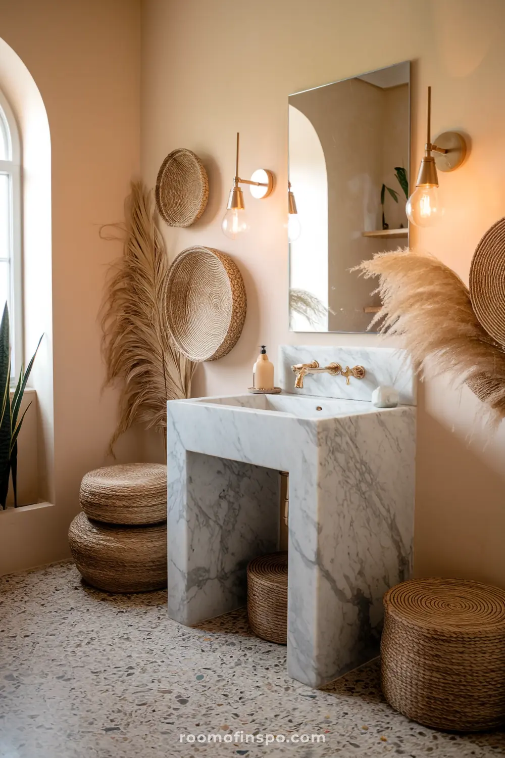 A bohemian bathroom with a marble sink, terrazzo flooring, and brass accents, combining luxury with boho textures.