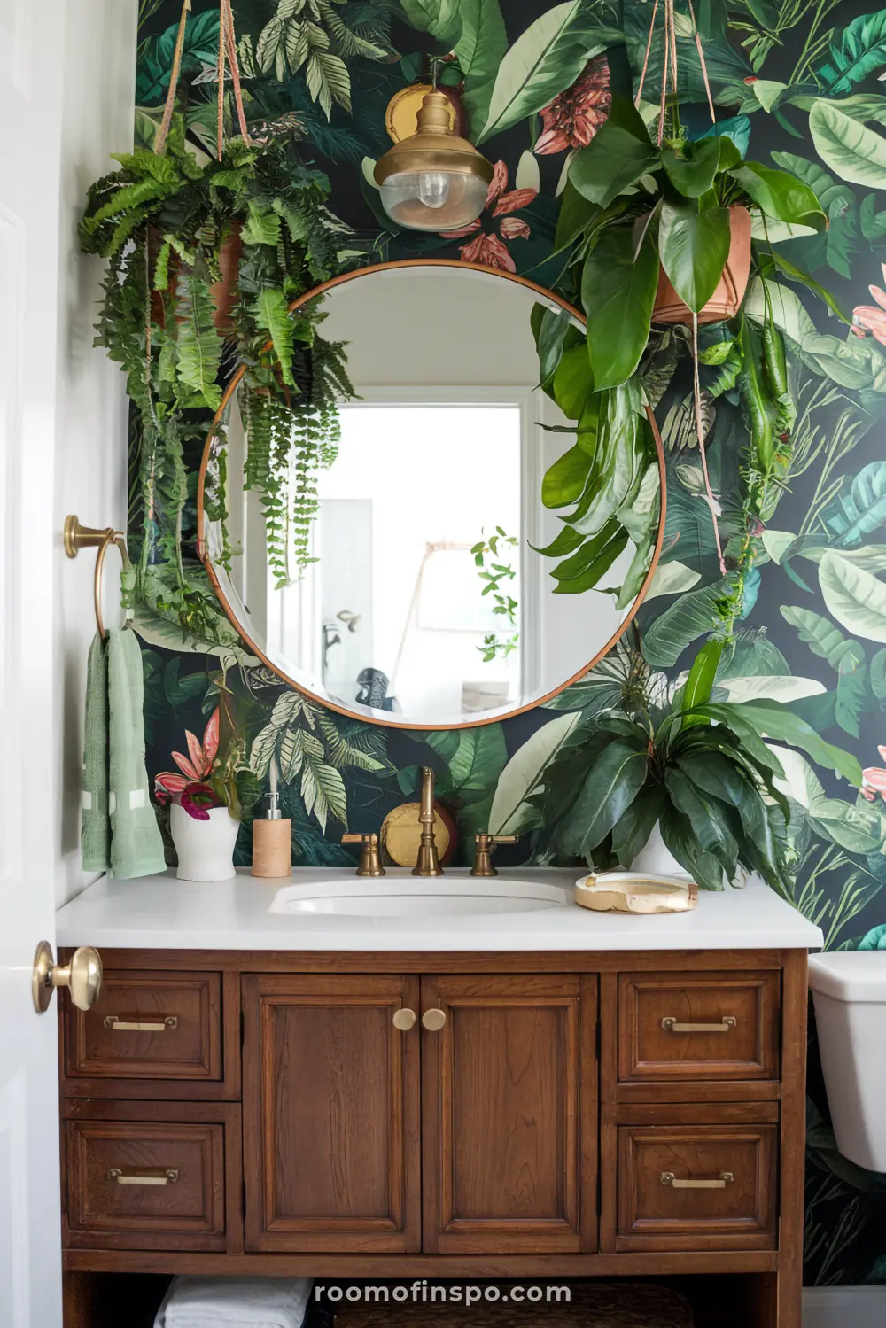A bohemian bathroom with lush greenery, tropical wallpaper, and a wooden vanity, evoking a jungle-inspired retreat.