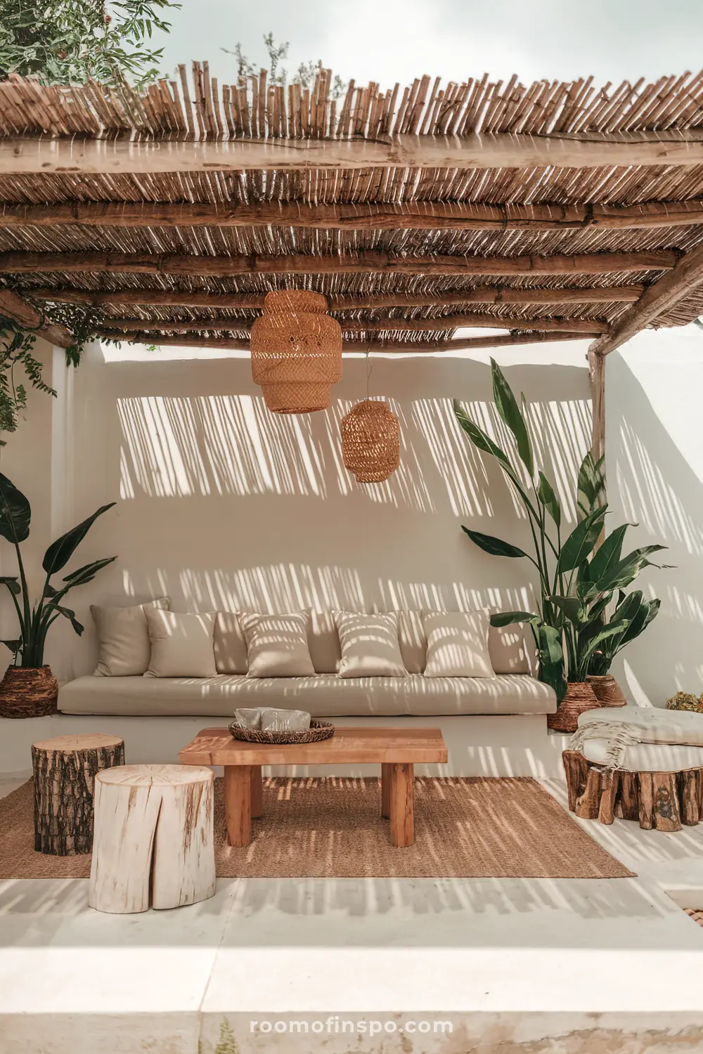 A cozy outdoor seating area with a thatched roof, wicker lanterns, and a natural wood coffee table.