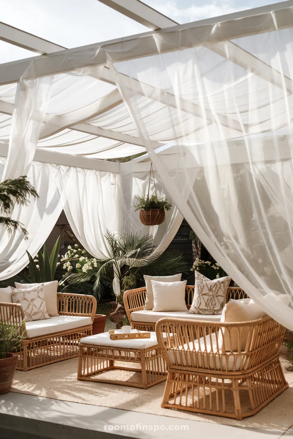 A covered patio with flowing sheer curtains and bohemian furniture creating a dreamy outdoor space.