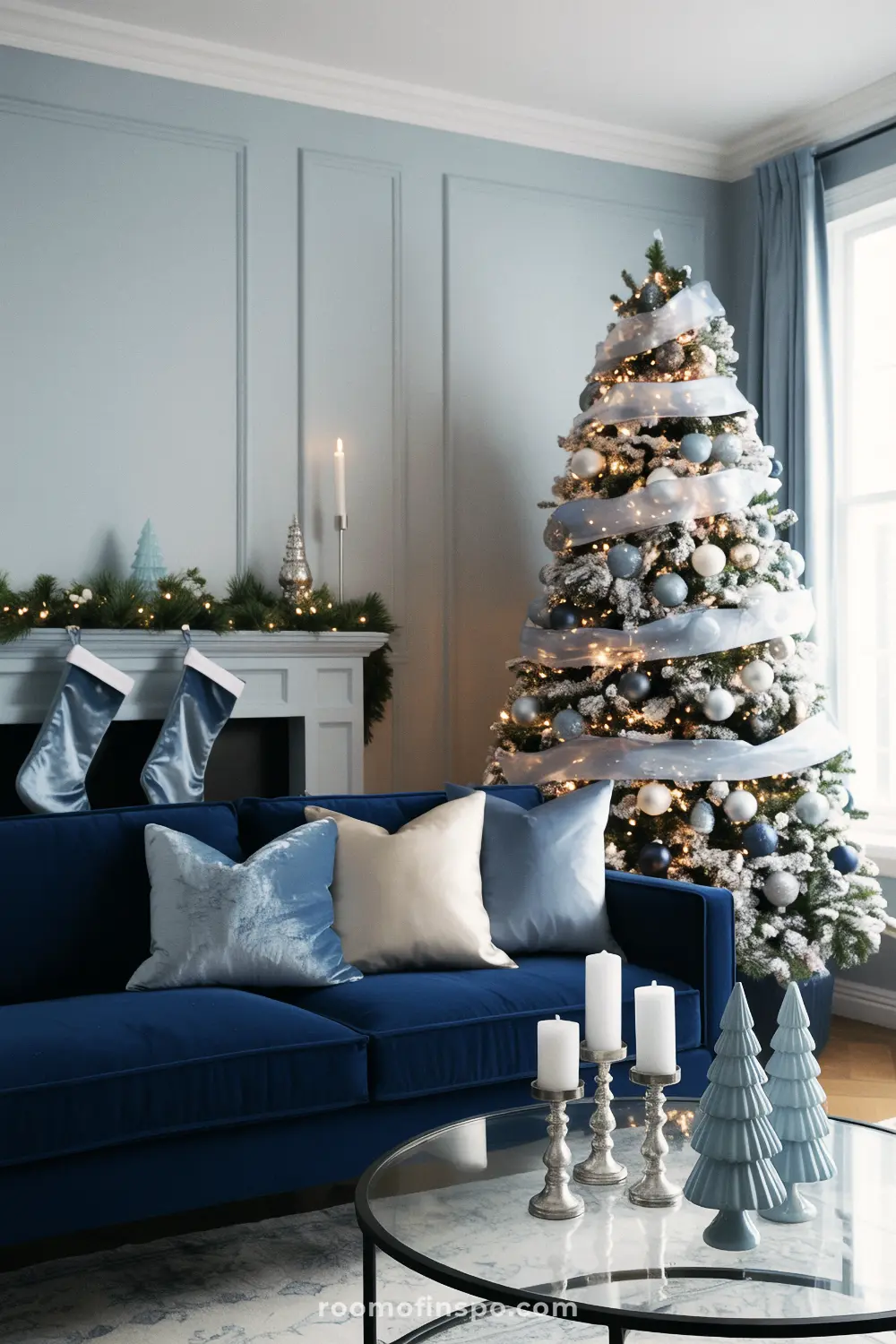 Shades of blue on the tree and sofa create an elegant, monochromatic theme in a beautiful living room for Christmas.