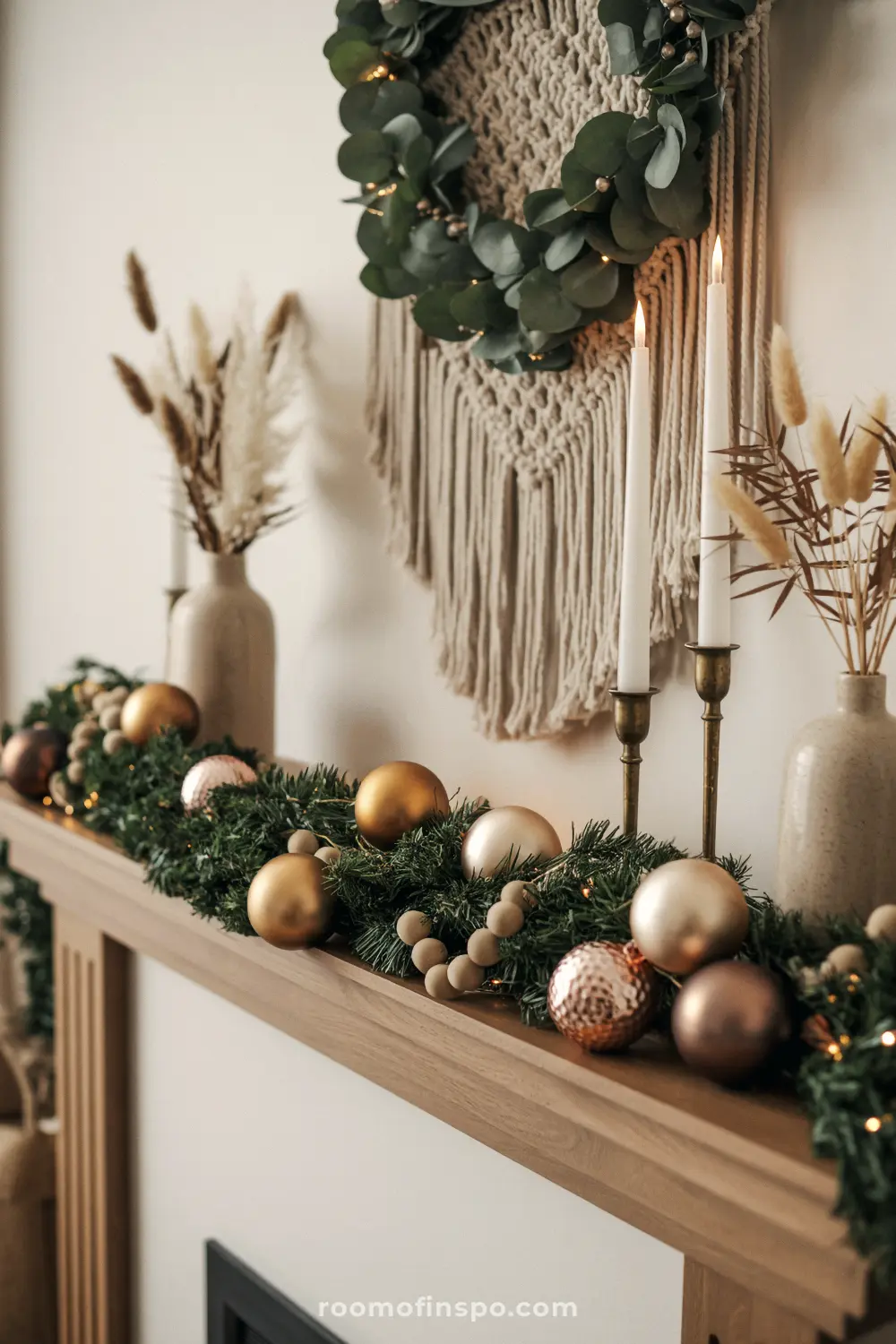 A cozy mantel features a macrame wall hanging with a greenery wreath, emphasizing the chic boho Christmas aesthetic.