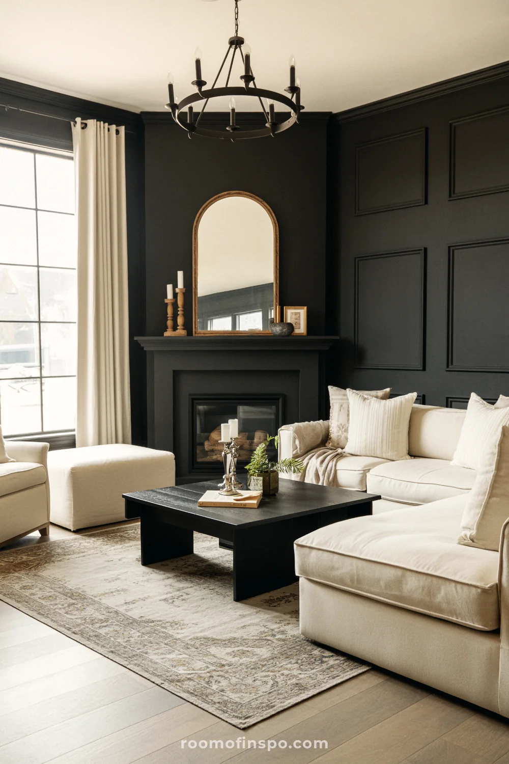 Living room with charcoal accent wall, sleek corner fireplace, beige seating, square black coffee table, and vintage-style rug.