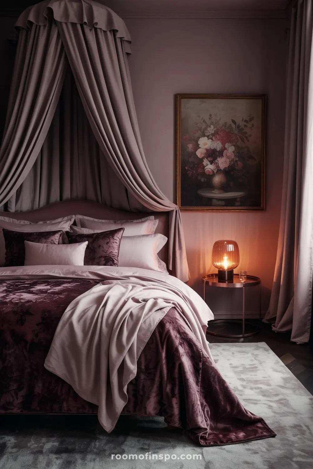 A moody and feminine bedroom with a canopy bed, a dark berry-toned comforter, and a painting of flowers.