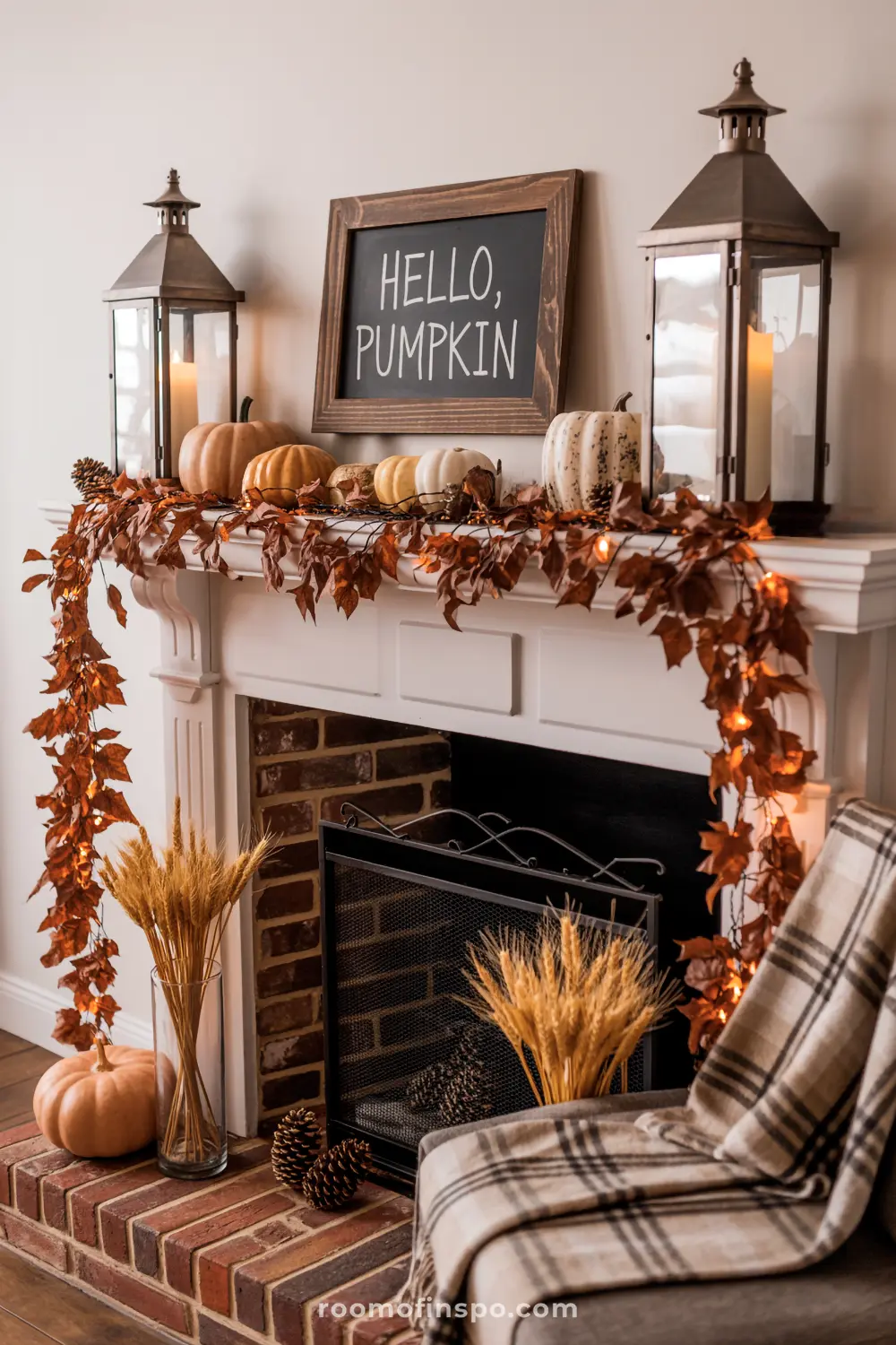A welcoming fall mantel features a "Hello, Pumpkin" sign, decorative pumpkins, two lanterns, and a lit autumn leaf garland.