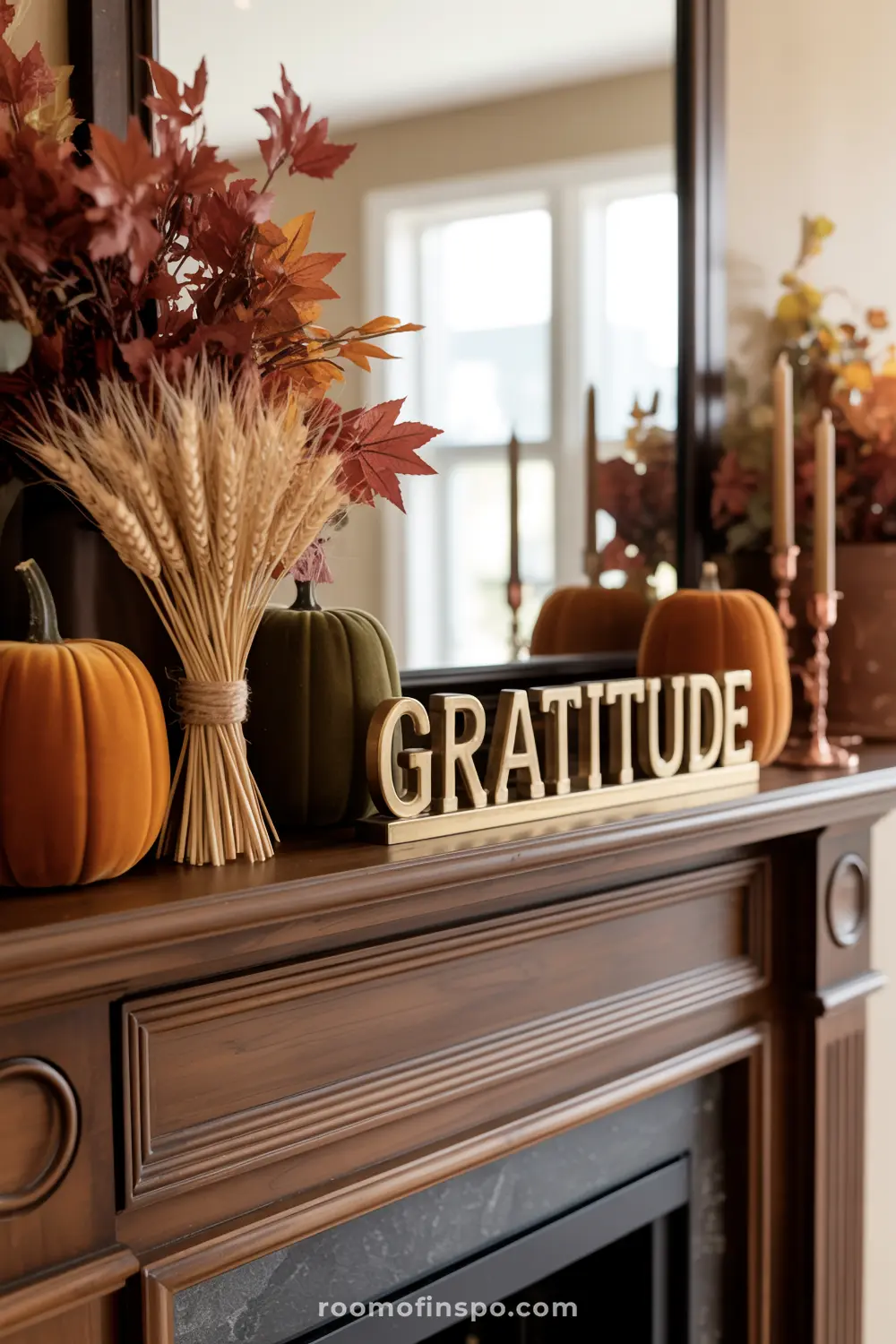 A rich wooden mantel displays a "GRATITUDE" sign, velvet pumpkins, wheat, and fall foliage, creating a warm autumn display.