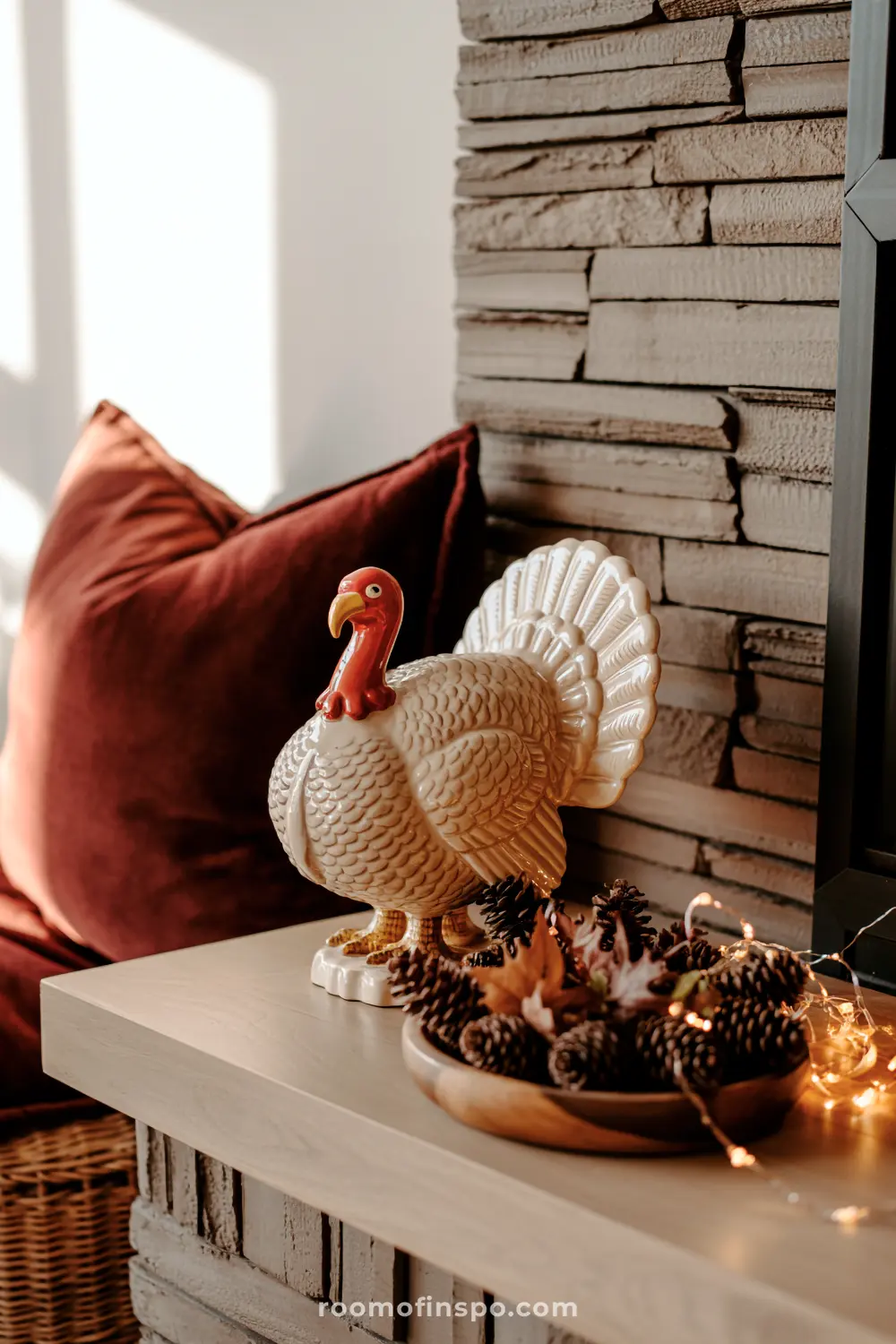A turkey figurine stands beside a bowl of pinecones and twinkling lights, creating festive fall home decor perfect for autumn.