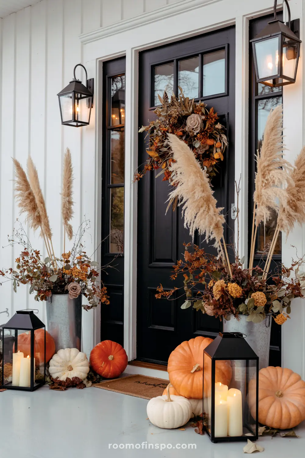 Feathery pampas grass, lanterns, and pumpkins beautifully decorate a fall front porch, celebrating the autumn season.