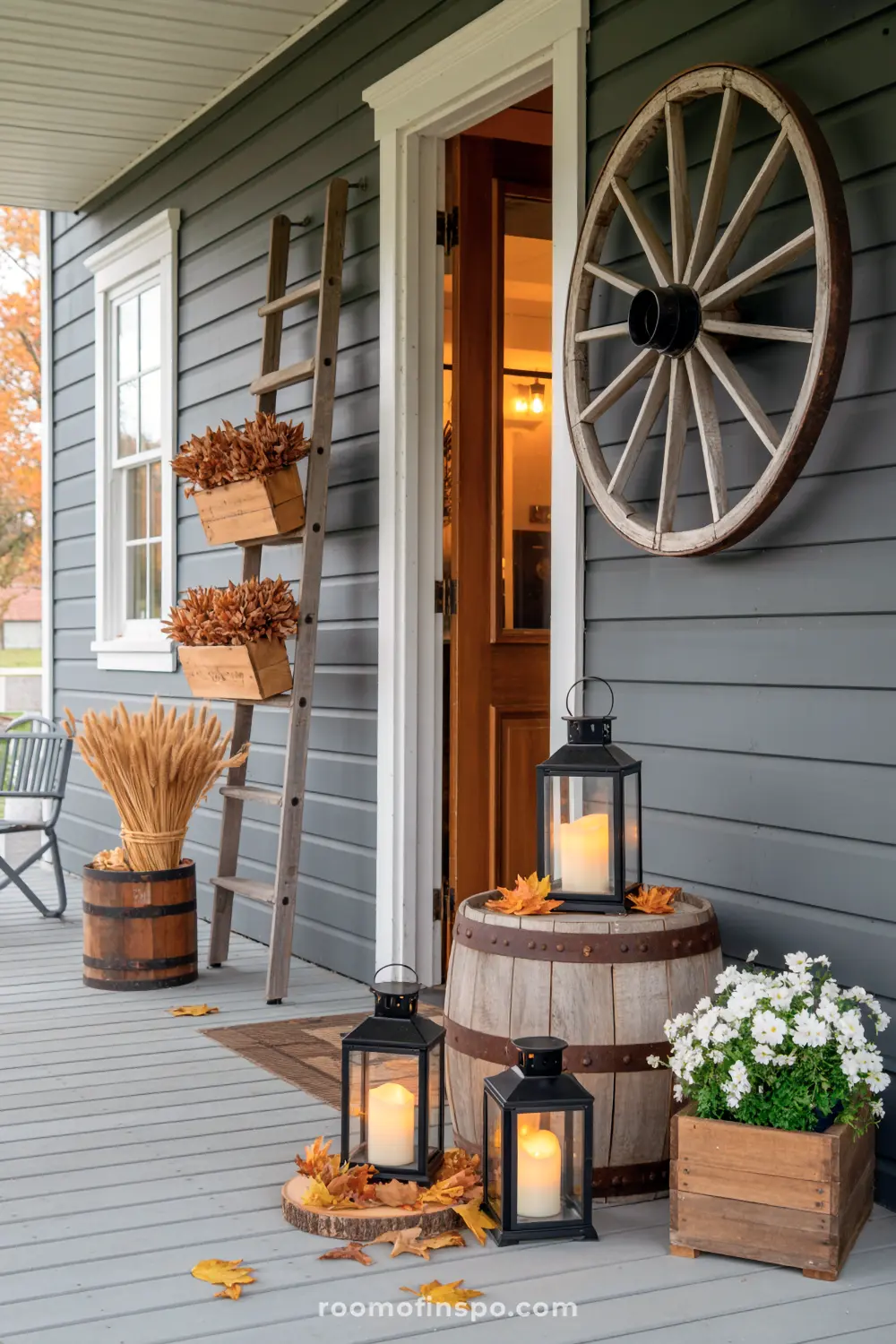 Black lanterns, wooden barrels, and a wagon wheel decorate a rustic fall front porch for autumn.