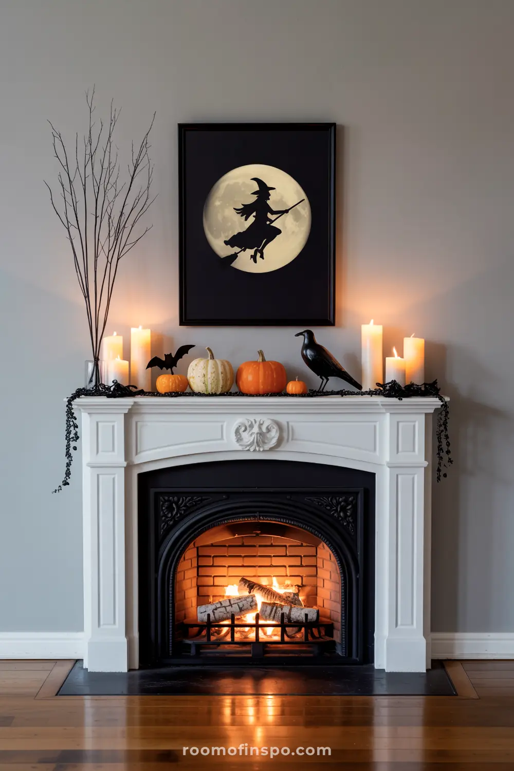 A classic Halloween mantel displays a witch on a broomstick against a full moon, flanked by pumpkins, candles, a crow, and bare branches.
