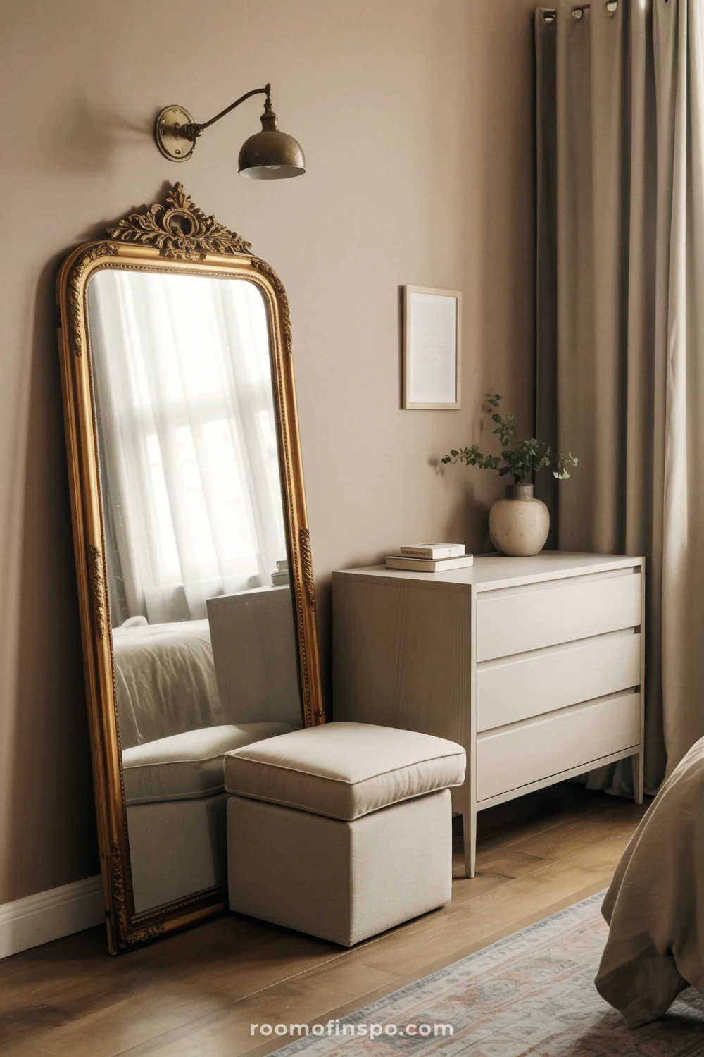Bedroom with ornate antique mirror, modern oak dresser, linen bench, and soft morning light through curtains.