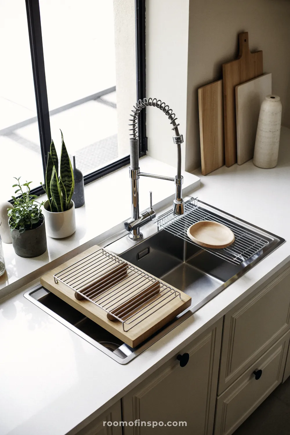 An industrial-style kitchen showcasing exposed ventilation and dark, sustainable materials in a highly modern, minimalist space.