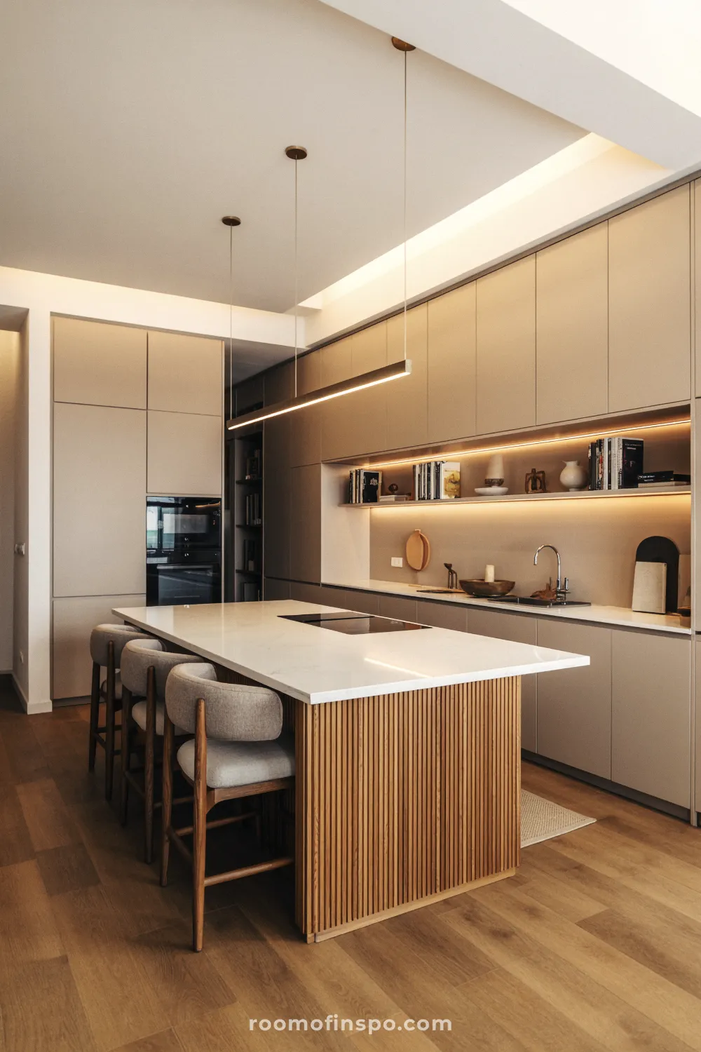 A stylish, warm-toned kitchen with a large island and a view into a living space, focusing on open sightlines and flow.