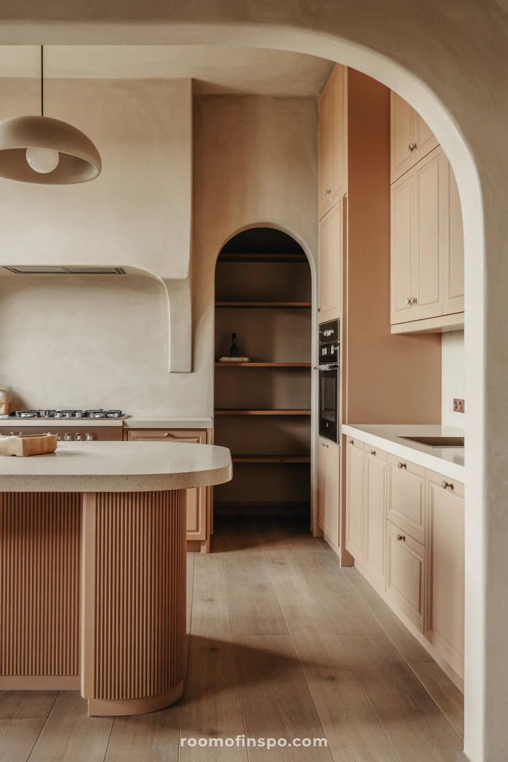 A sophisticated kitchen incorporating a curved, arched opening in the cabinetry, softening the room's overall aesthetic.