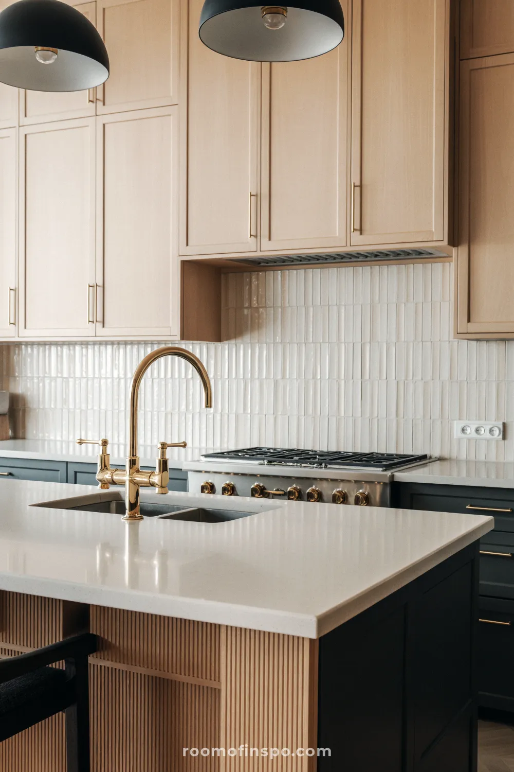 A transitional kitchen with light shaker cabinets and a dark island, centered around a prominent, high-end statement range.
