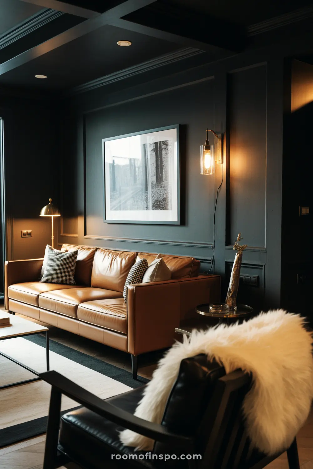 A luxurious masculine living room with a brown leather sofa, a black-and-white print above it, and a white fluffy cushion.