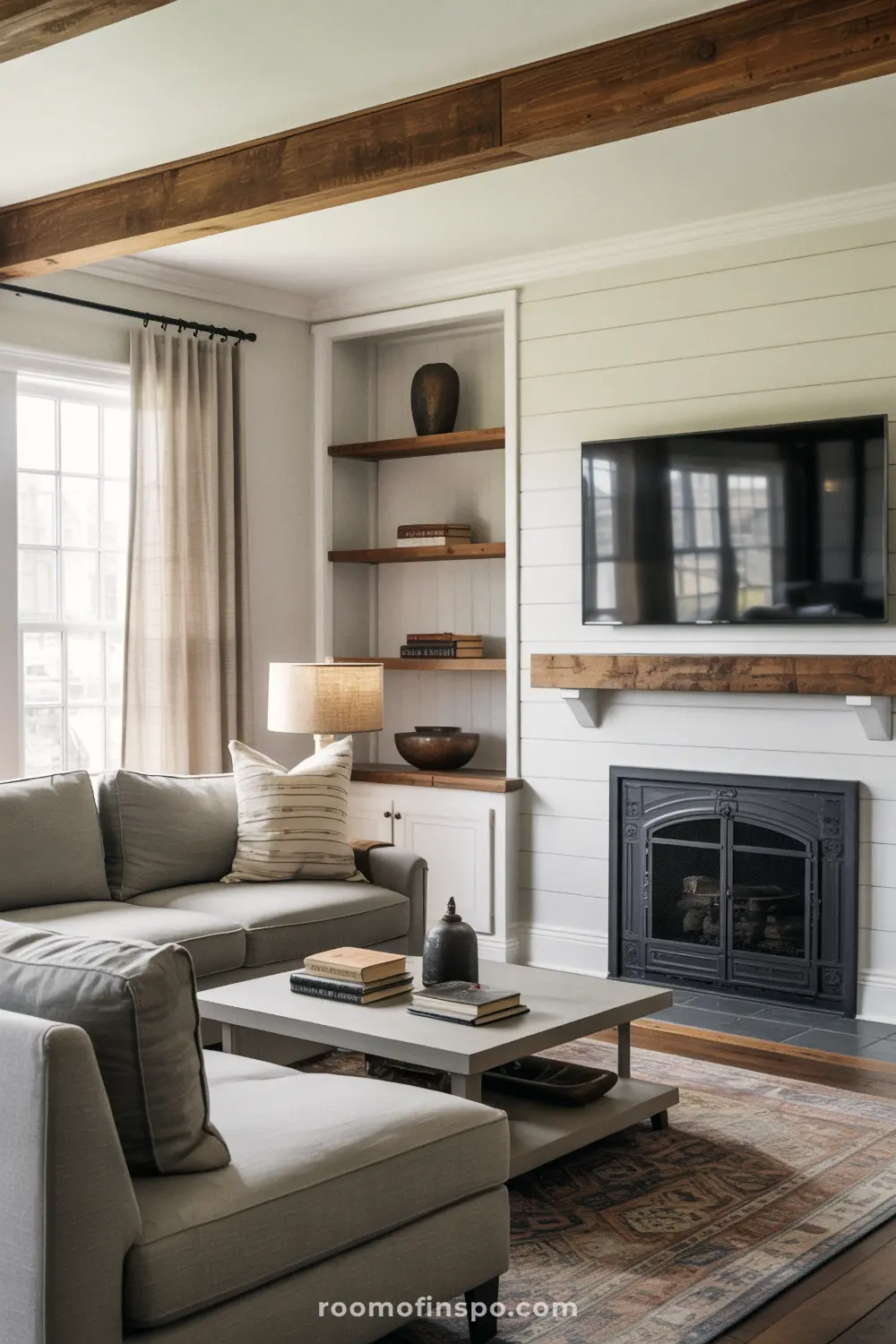 A masculine living room in a farmhouse style with a gray sofa, a fireplace, and a large TV on a wooden wall.