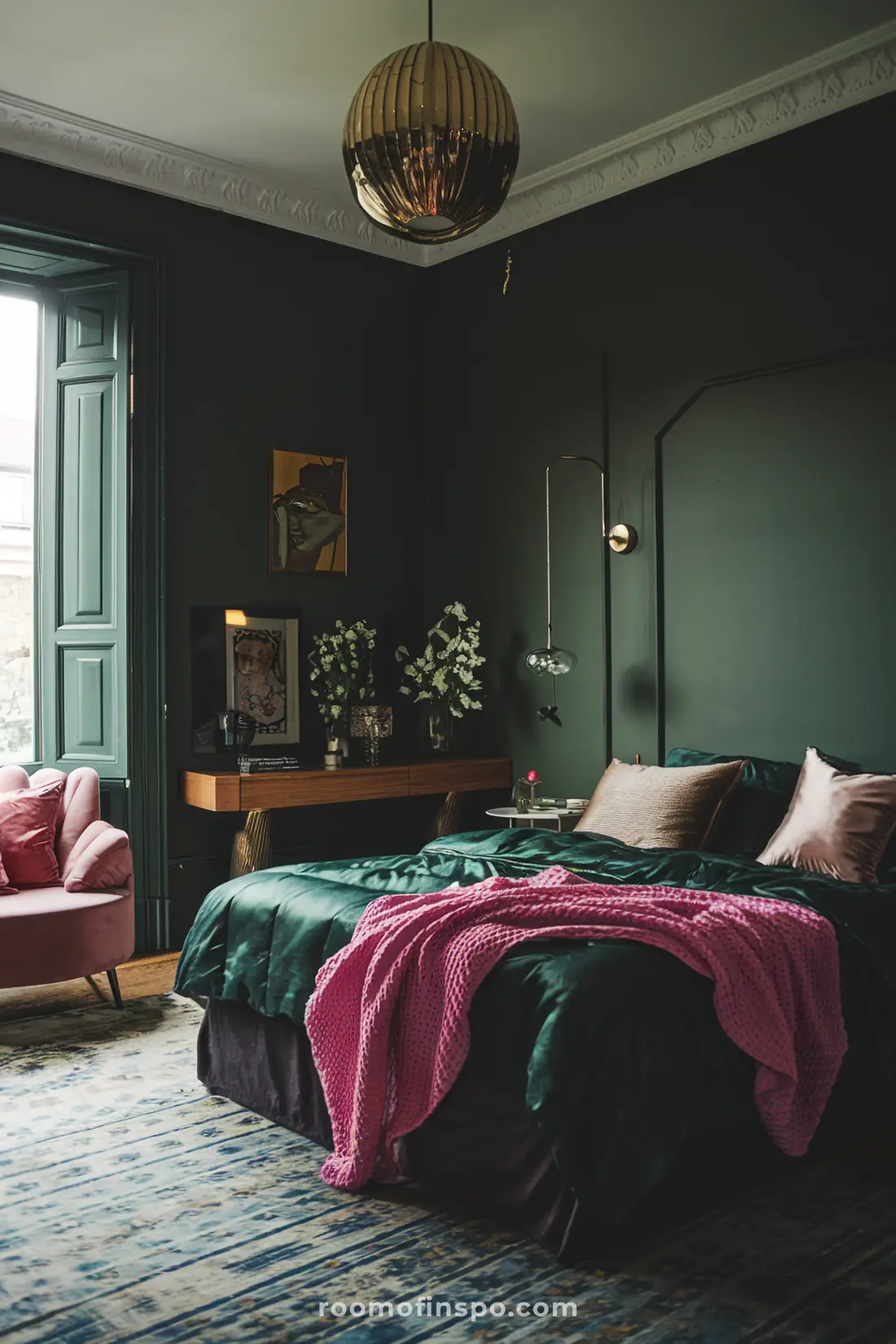 Moody bedroom with deep green matte walls, brass fixtures, pink accents, and layered decor.