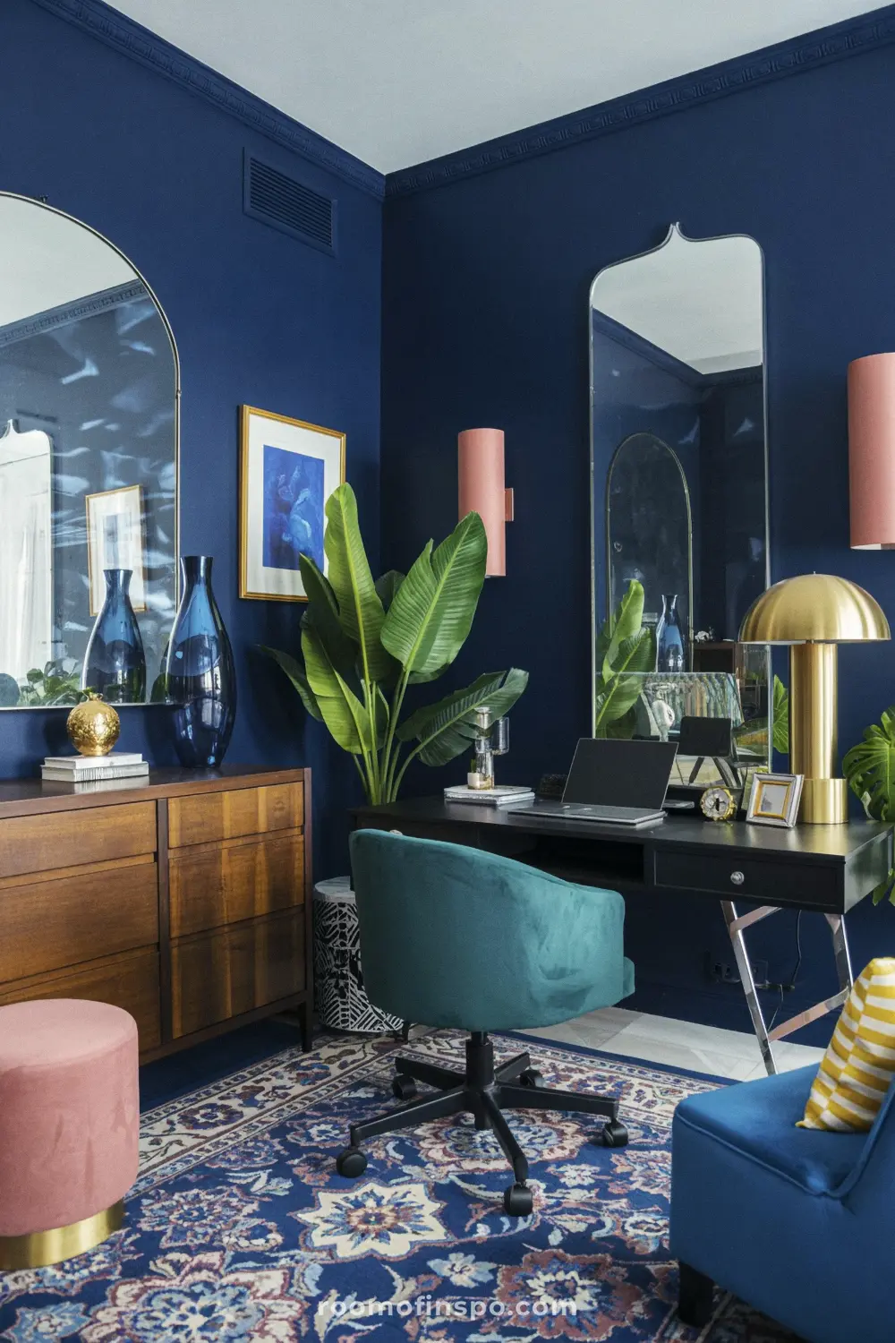 A home office with a dark accent wall, maximalist decor, and laptop.