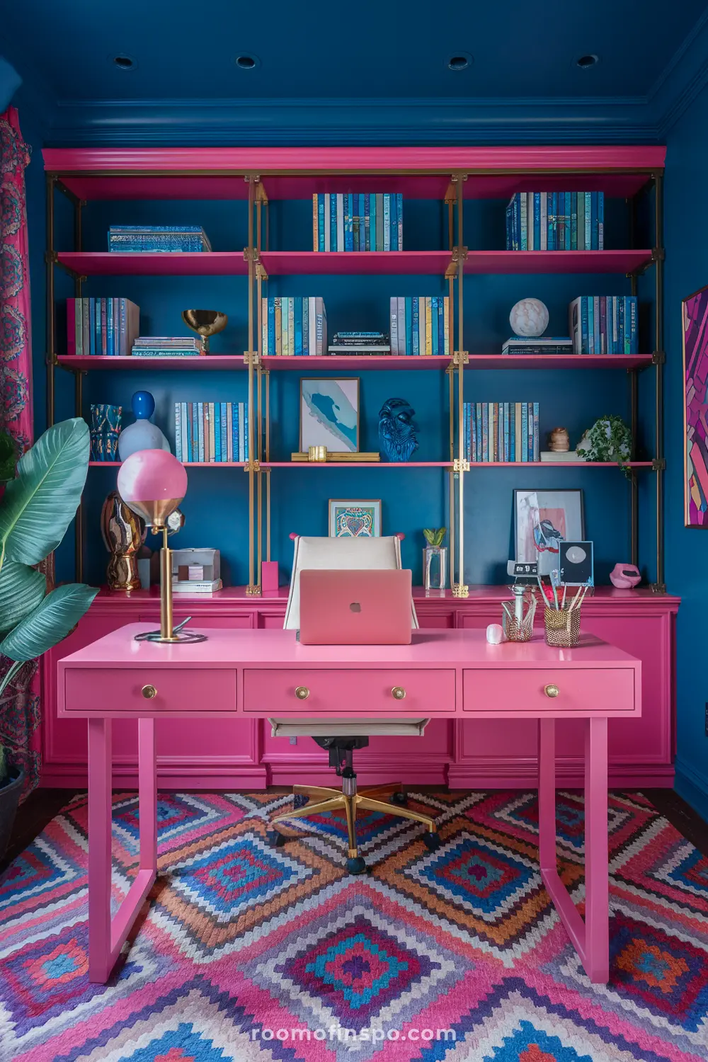 A pink maximalist home office with gold accents and laptop.
