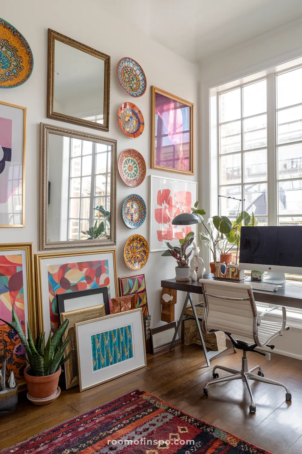 A maximalist home office with a layered wall collage and monitor.