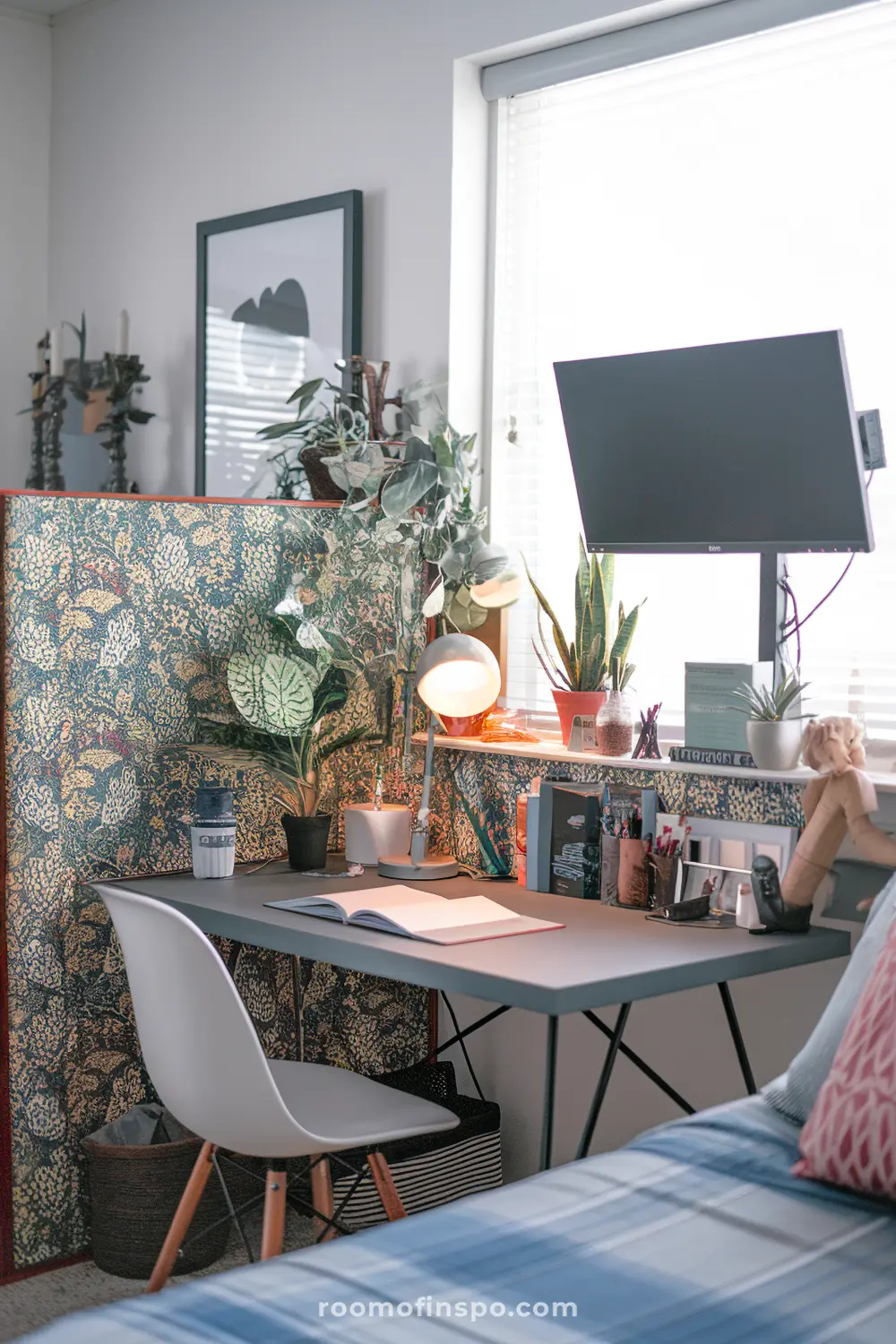 A bedroom-maximalist home office with vibrant touches and monitor.