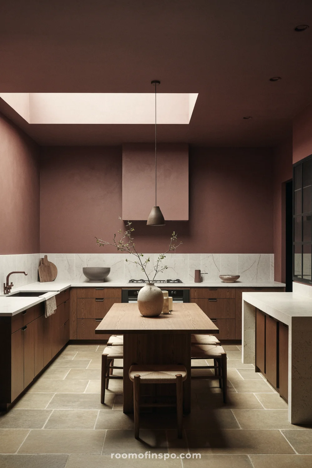Moody brown kitchen-dining area with quartz counters, dark wood cabinets, limestone floor, and bronze pendant lighting.