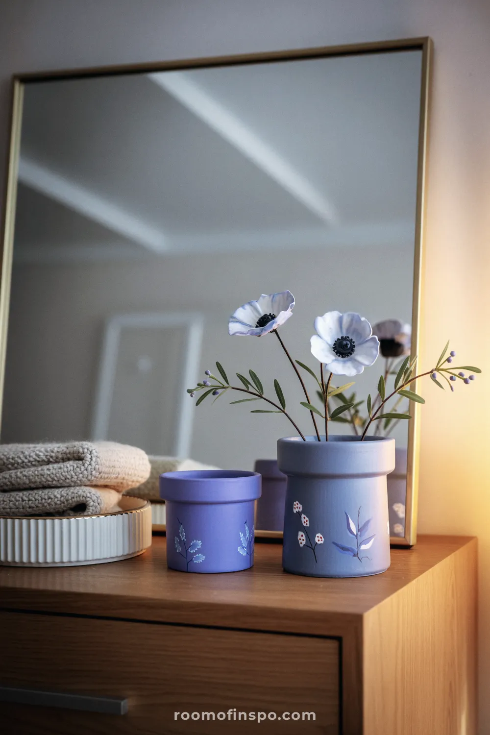 Blue floral-painted terracotta pot on a soapstone counter near white ceramics and a wooden cutting board.