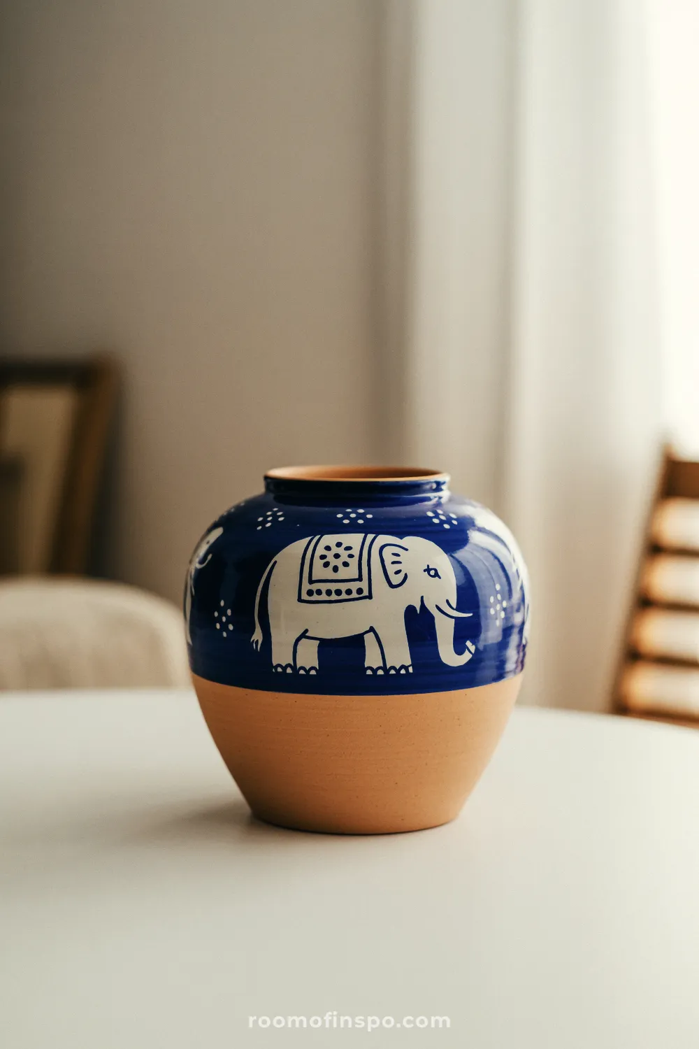 Two-tone pot with deep blue top and white elephant motif on a light surface indoors.