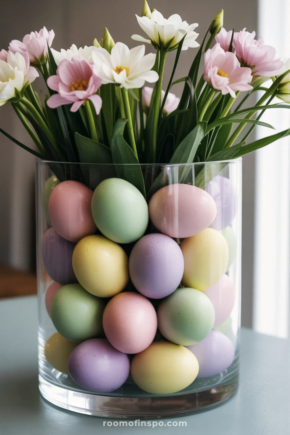 Decorative eggs and fresh flowers in pastel shades create a playful, festive Easter-themed centerpiece.