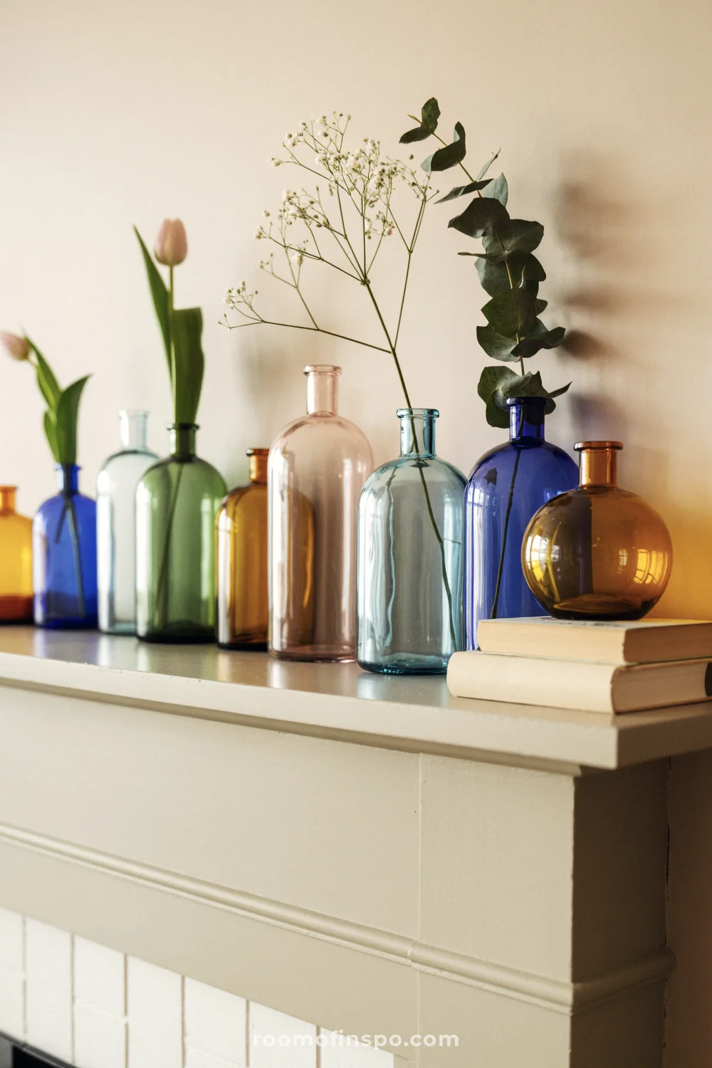 Close-up of spring-colored apothecary bottles arranged in a neat row on a white mantel with minimal stems.
