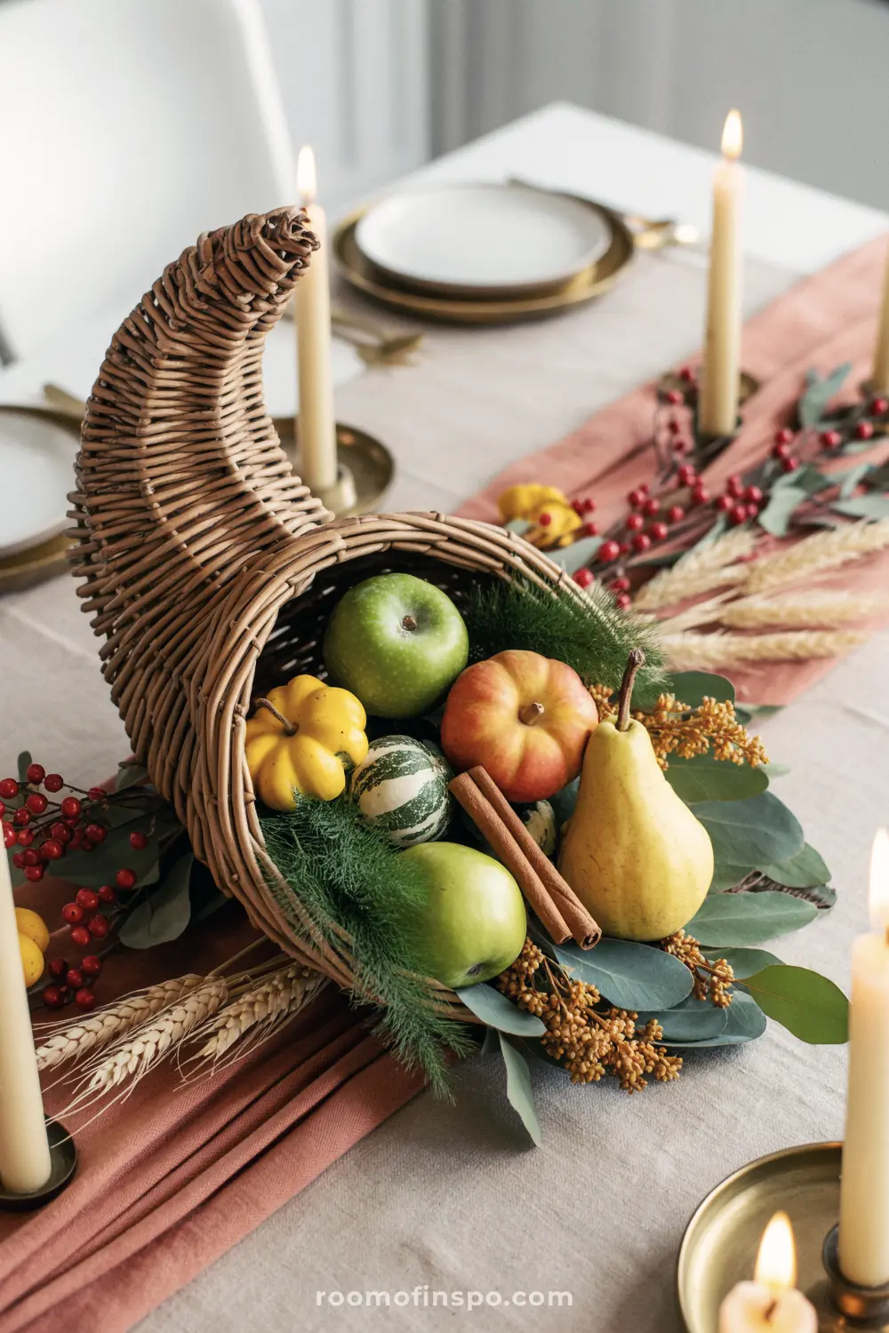 A beautiful Fall centerpiece featuring a wicker cornucopia filled with gourds, apples, a pear, and cinnamon sticks.