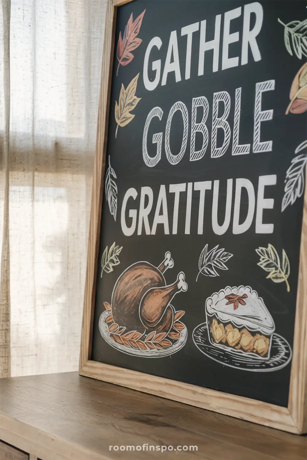 A wooden framed chalkboard with "Gather Gobble Gratitude" written in white for a thanksgiving celebration.