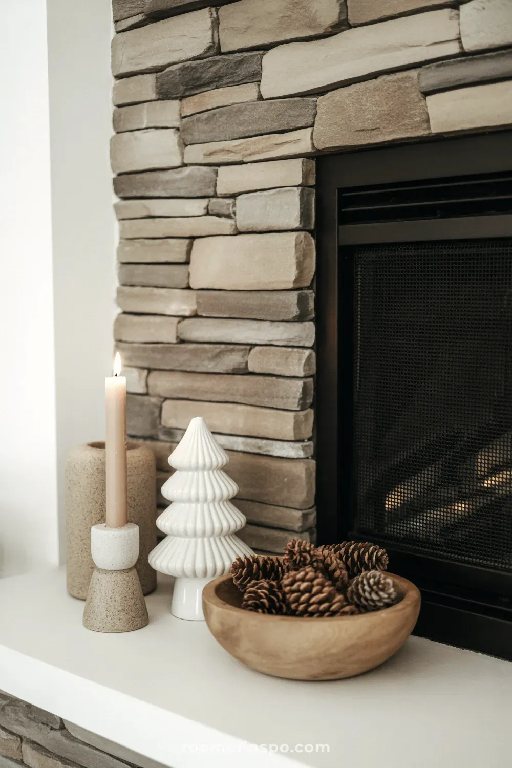 A stoneware fireplace white accessories create a quiet, stone-themed winter look on a modern fireplace mantel.