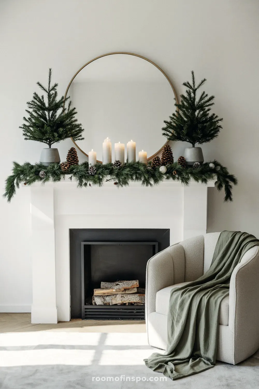 A simple and elegant winter mantel decorated with two green wreaths and a white garland over the black fireplace.