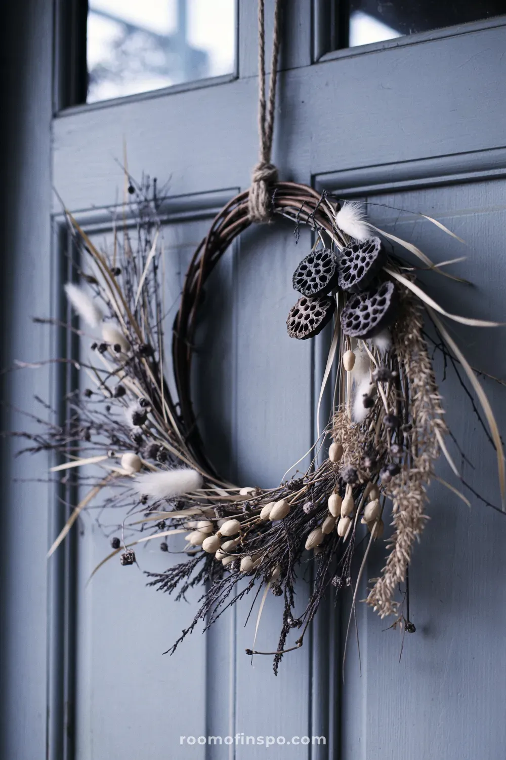 A rustic winter wreath created from natural twisted twigs and dried grasses, offering a simple, earthy, foraged design.